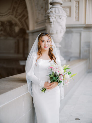 4th floor balcony portrait of a bride after her ceremony at SF city hall